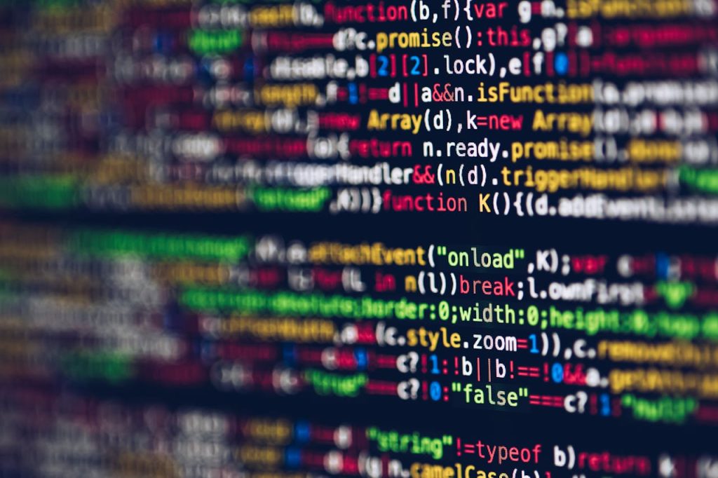 Vivid, blurred close-up of colorful code on a screen, representing web development and programming.